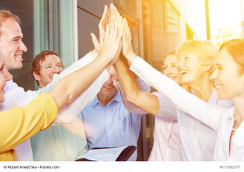 Sieben Personen geben sich ein High-Five