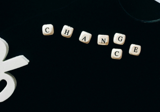 Mit Würfeln wurde das Wort Change gelegt, wobei unter dem G auch ein C ist, wodurch auch das Wort Chance entsteht. Zusätzlich ist ein Prozentzeichen, eine Maus und eine Lupe zu sehen.