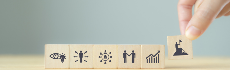 Eine Hand stellt Würfel mit Symbolen auf